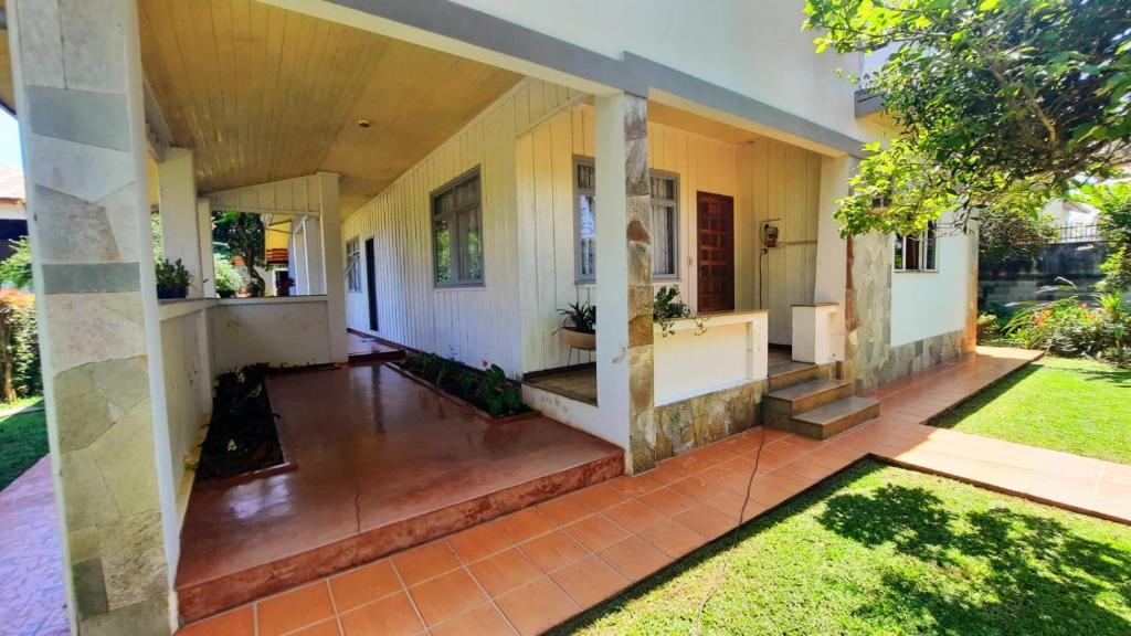 une terrasse couverte ouverte d'une maison avec une cour dans l'établissement Quartos em Casa próximo ao Parque Bacacheri, à Curitiba