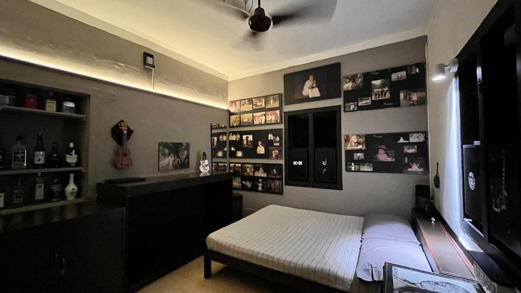 um quarto com uma cama e uma prateleira de fotografias em Apartment Near Indiranagar Metro Station. em Bangalore