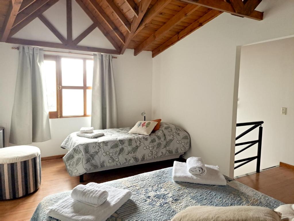 um quarto com duas camas e uma janela em Pirca Ushuaia em Ushuaia