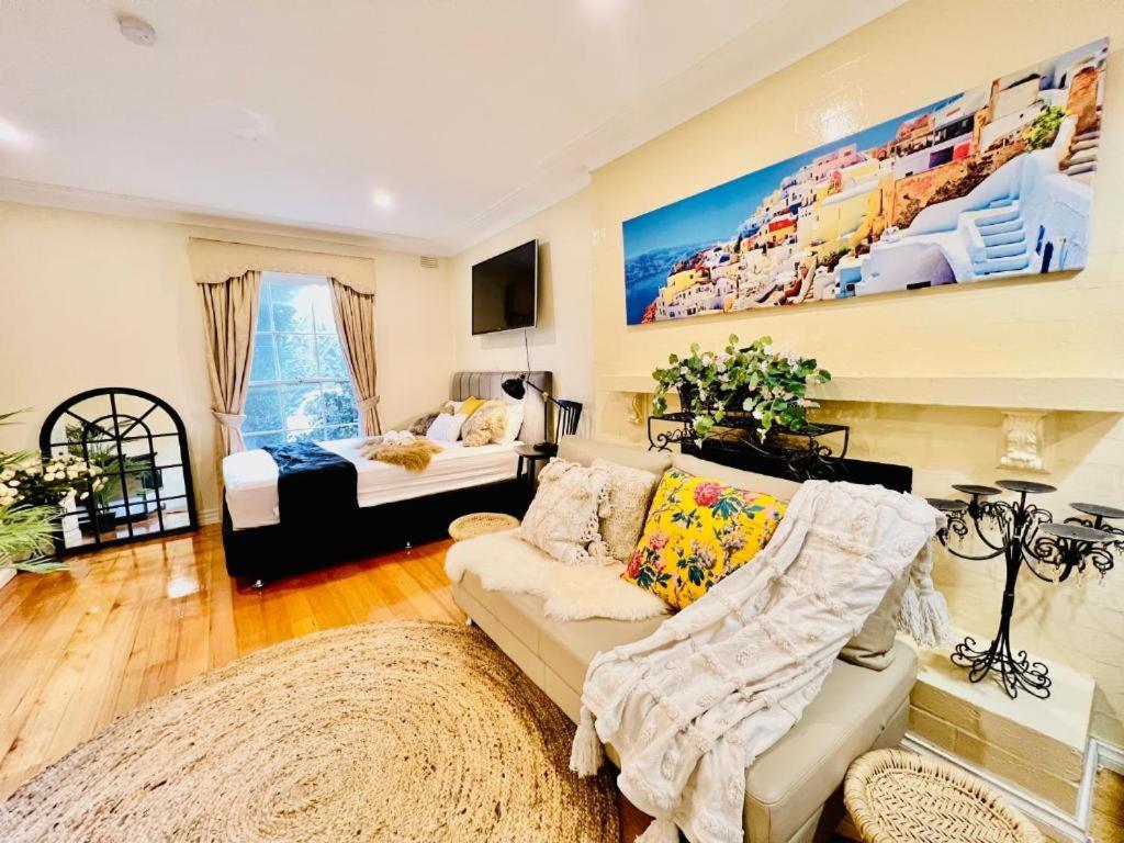 een woonkamer met een bank en een bed bij Cozy Self Contained Studio with Seperate Spacious Living room -Just a Stone's Throw from Newly Renovated Knox Westfield in East Melbourne in Wantirna South
