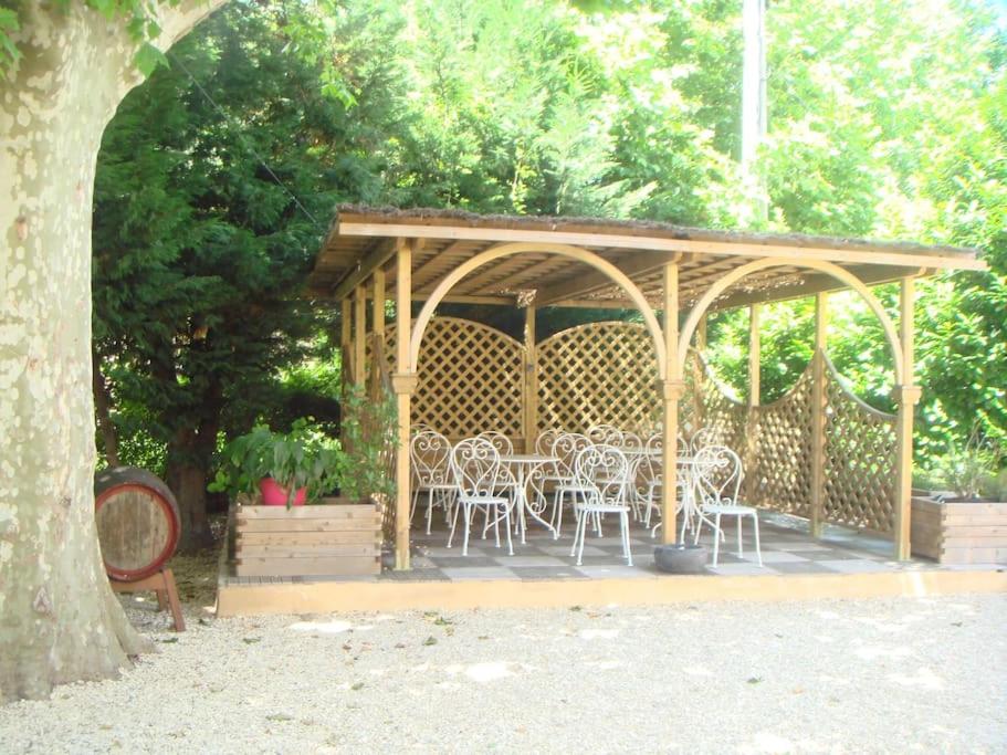 a wooden gazebo with white chairs and tables at Studio « Saint-Petersbourg » à Avignon in Avignon
