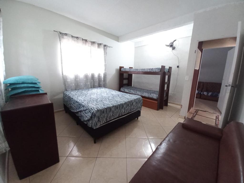 a small bedroom with two beds and a mirror at Residência in Caraguatatuba