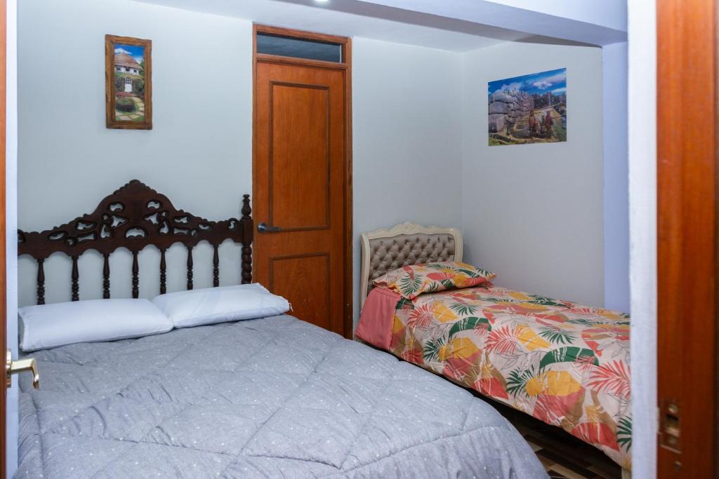 1 dormitorio con 1 cama y puerta de madera en TRANSFER VIP HOSTEL, en Lima