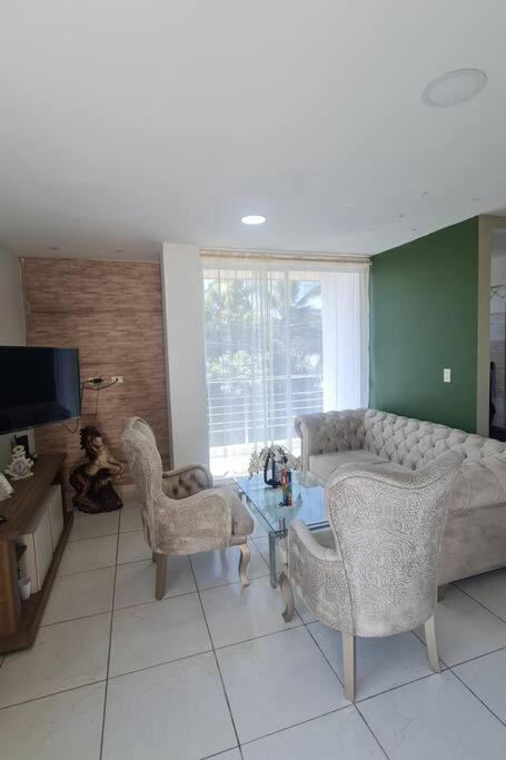 sala de estar con sofá y 2 sillas en Lindo departamento en conjunto multifamiliar, en Barranquilla