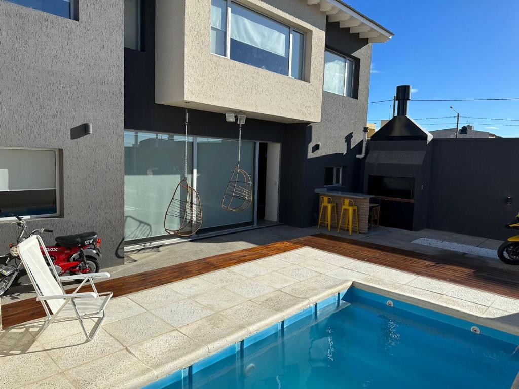 una casa con piscina frente a una casa en MADRYN APARTS en Puerto Madryn