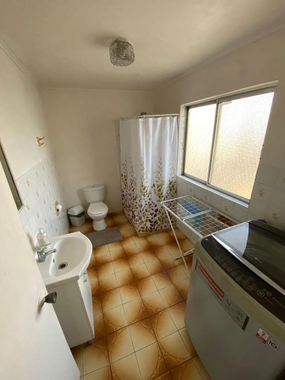 uma casa de banho com um lavatório, um WC e um chuveiro em Central y Tranquilo alojamiento em Villa Alemana