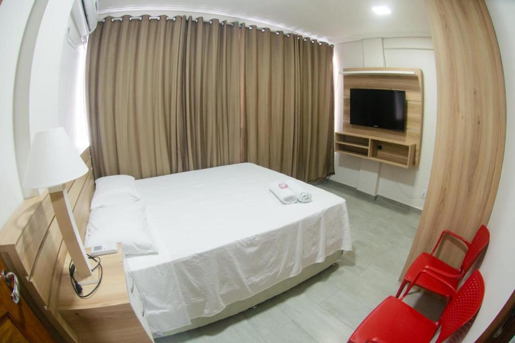 a hotel room with a bed and a television at Modelo flat apartamento 603 in Manaus