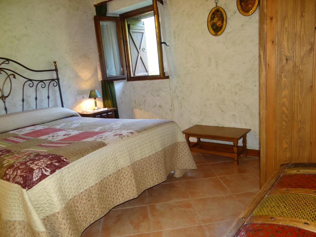 a bedroom with a bed and a window and a table at Casa Rural Calzon Ordesa in Oto
