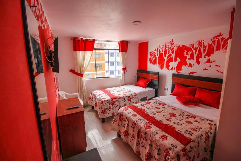 a red room with two beds and a window at Hotel D'Gloria in Churín