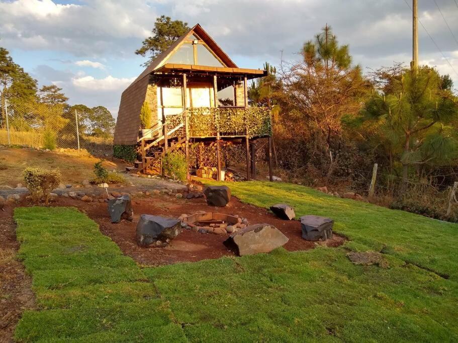 un pequeño edificio con rocas en un patio en Villas Margarita, Mazamitla, Jalisco., en Mazamitla