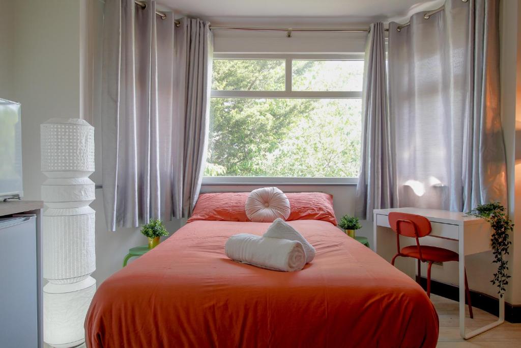 a bedroom with an orange bed with a window at Luxury Boutique Studio London in London