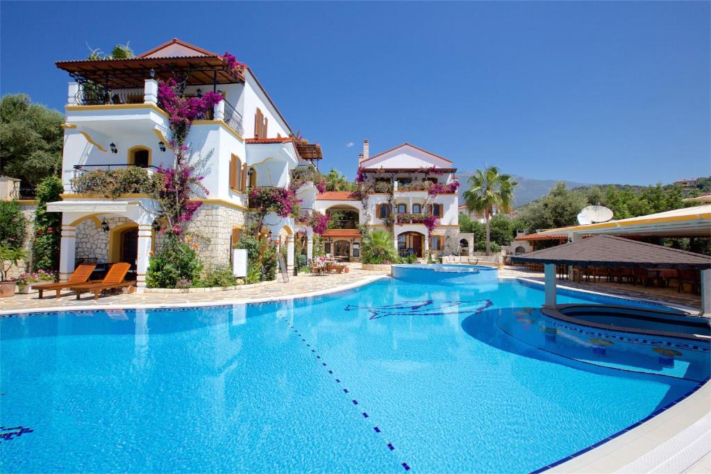 a large swimming pool in front of a building at Hadrian Hotel in Kaş