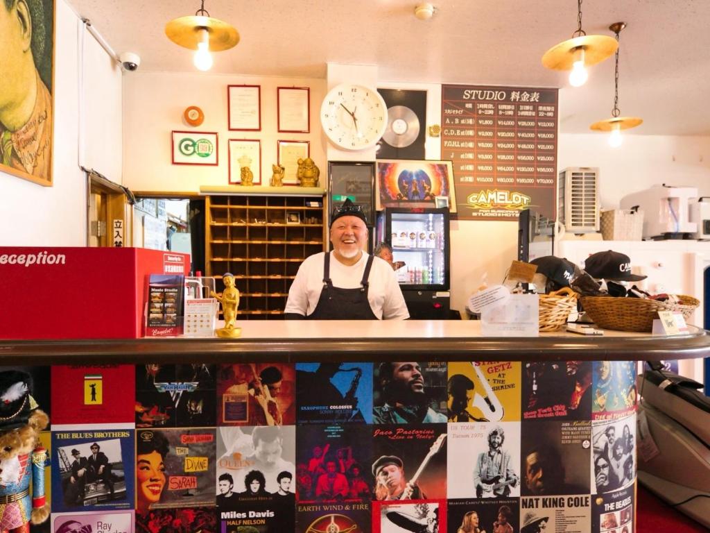 a man standing behind a counter in a restaurant at Hotel Camelot in Fujikawaguchiko