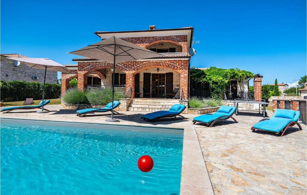 a pool with chairs and a red ball in front of a house at Villa Happy Holiday in Kurjavići