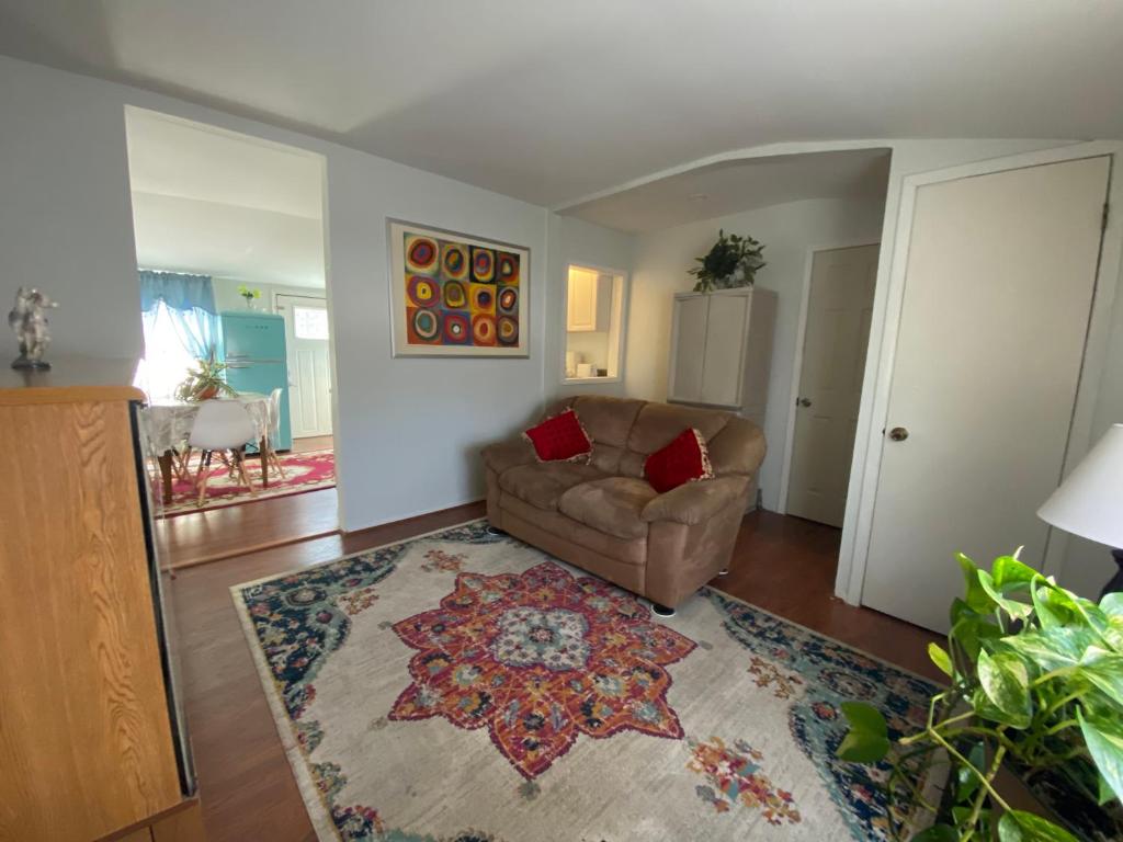 uma sala de estar com um sofá e um tapete em Two bedroom, living/dining room em Bellport