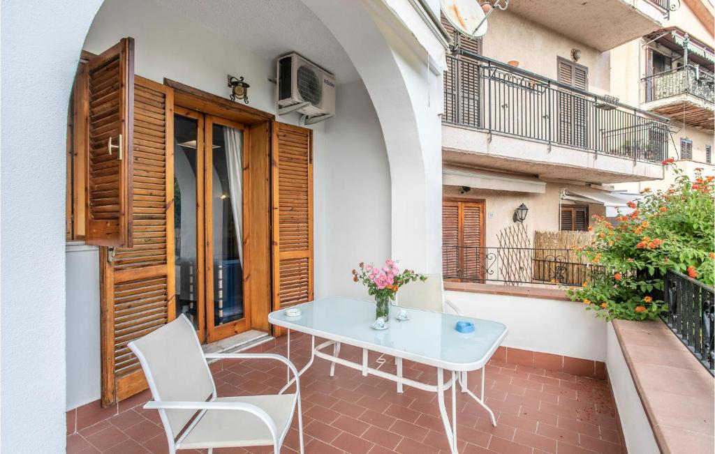een patio met een tafel en stoelen op een balkon bij 2 Bedroom Amazing Apartment In Giardini Naxos in Giardini Naxos
