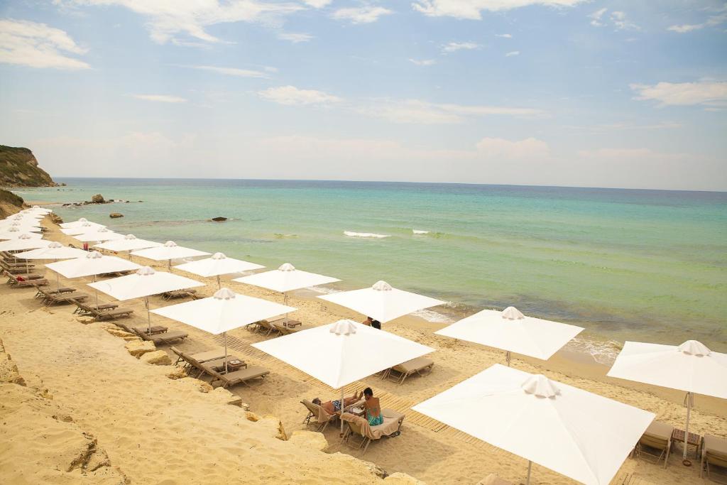 a row of white umbrellas on a beach at Sunny Hill in Sani Beach