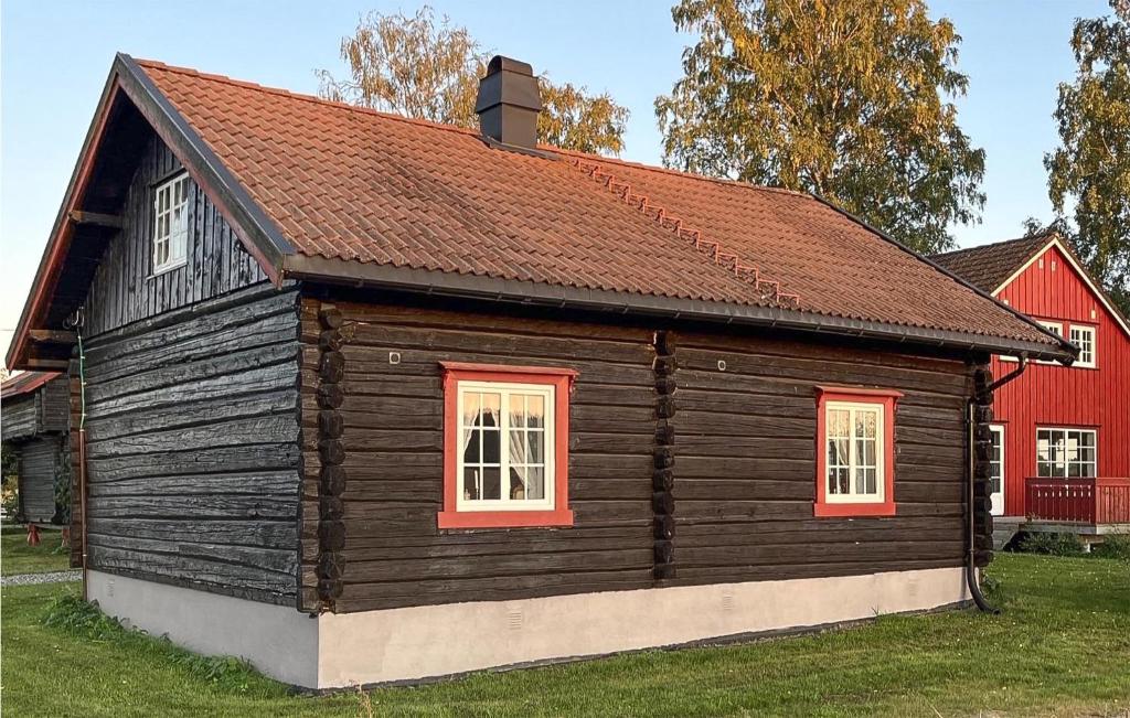 a wooden house with red windows and a red barn at 1 Bedroom Beautiful Home In Vormsund in Vormsund
