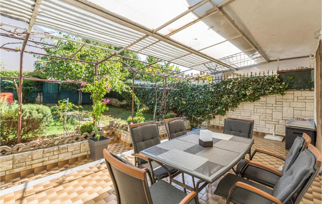 a patio with a table and chairs and a greenhouse at Stunning Home In Porec With Wifi in Poreč