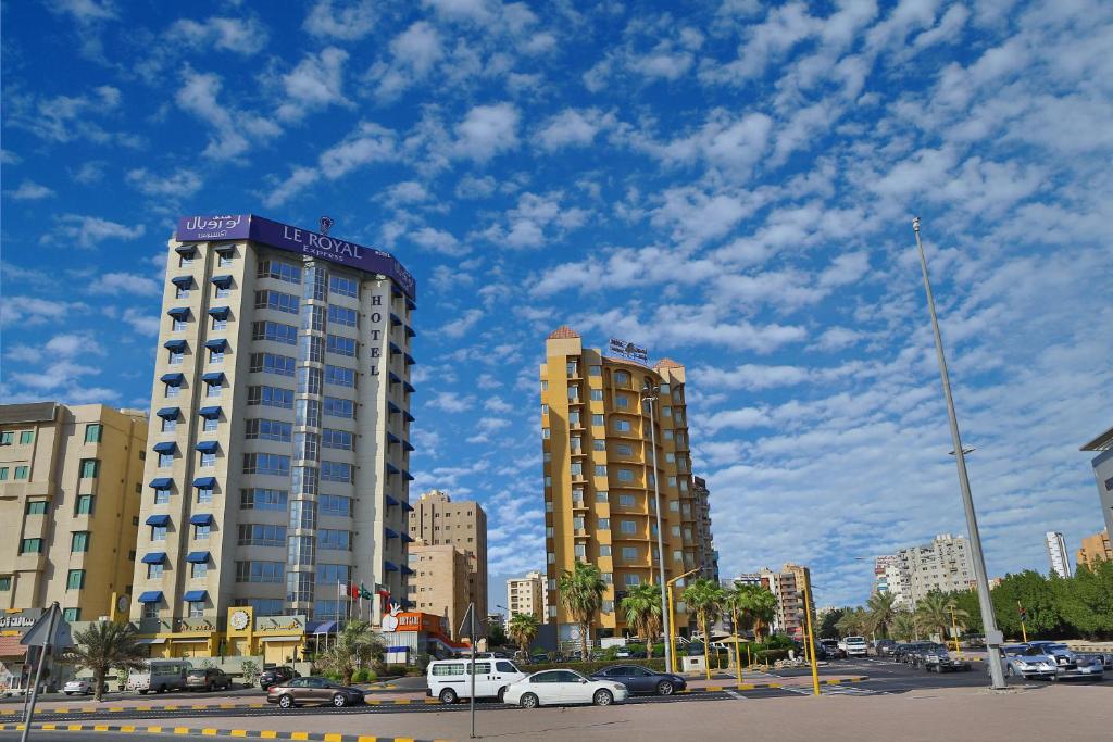 dos edificios altos en una ciudad con coches en Le Royal Express Salmiya, en Kuwait