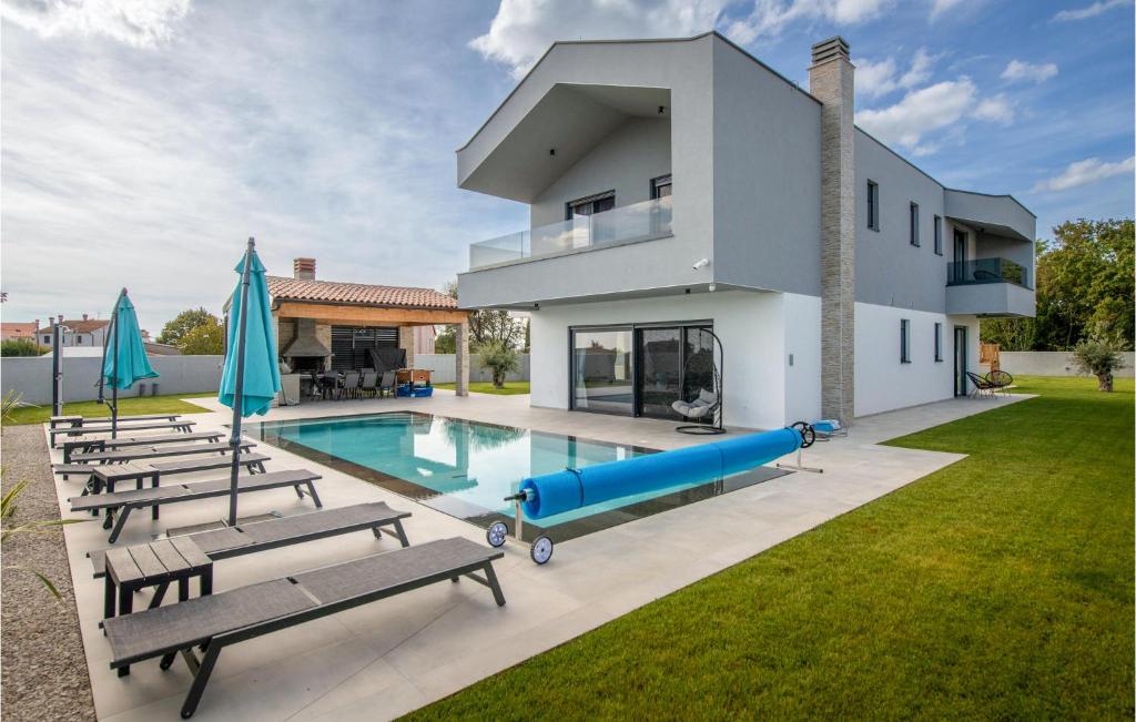 een villa met een zwembad en een huis bij Cozy Home In Rebici With Outdoor Swimming Pool in Rebići