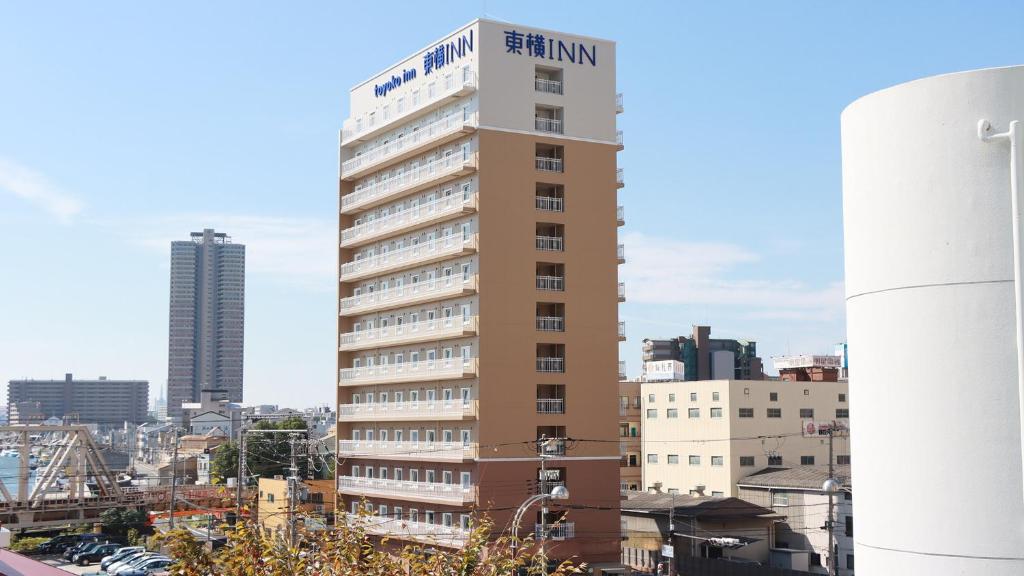 a tall building with a sign on top of it at Toyoko Inn Osaka Dome Mae in Osaka
