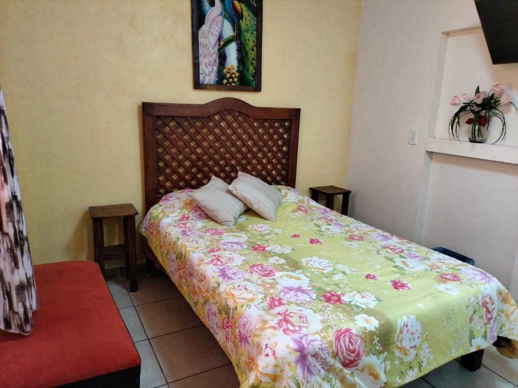 um quarto com uma cama com colcha floral em HOSPEDAJE 4Casa San Francisco em Zacatlán