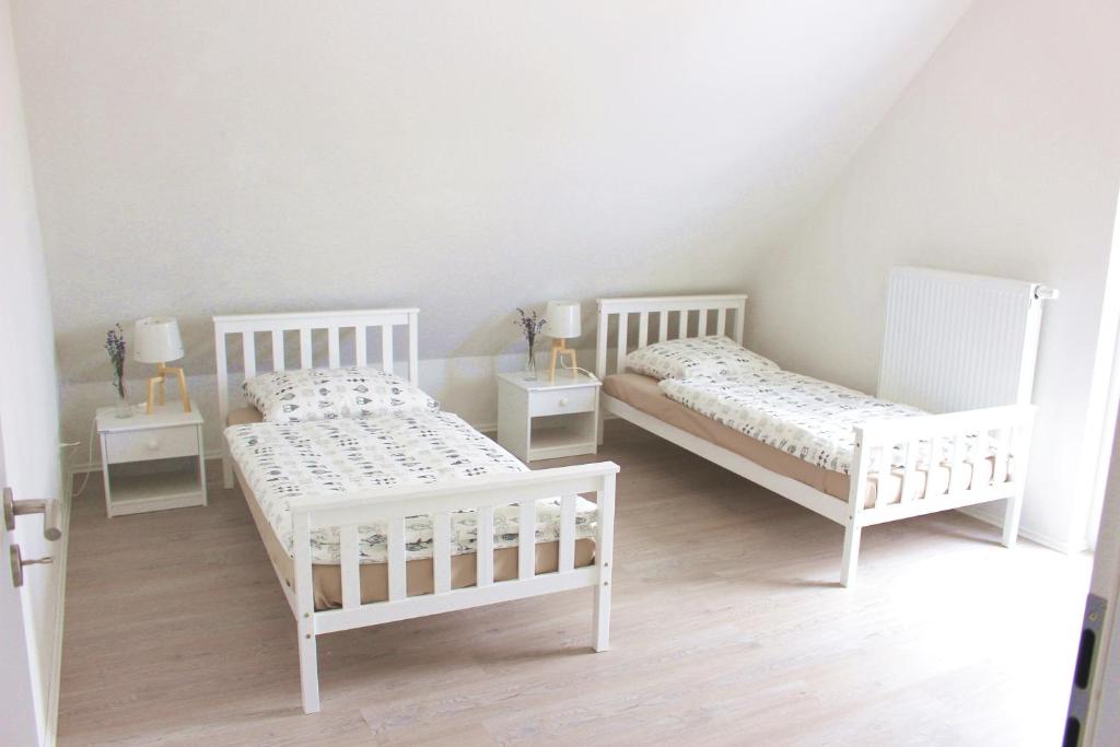 two white beds in a room with two tables at Dornfelder in Hanhofen