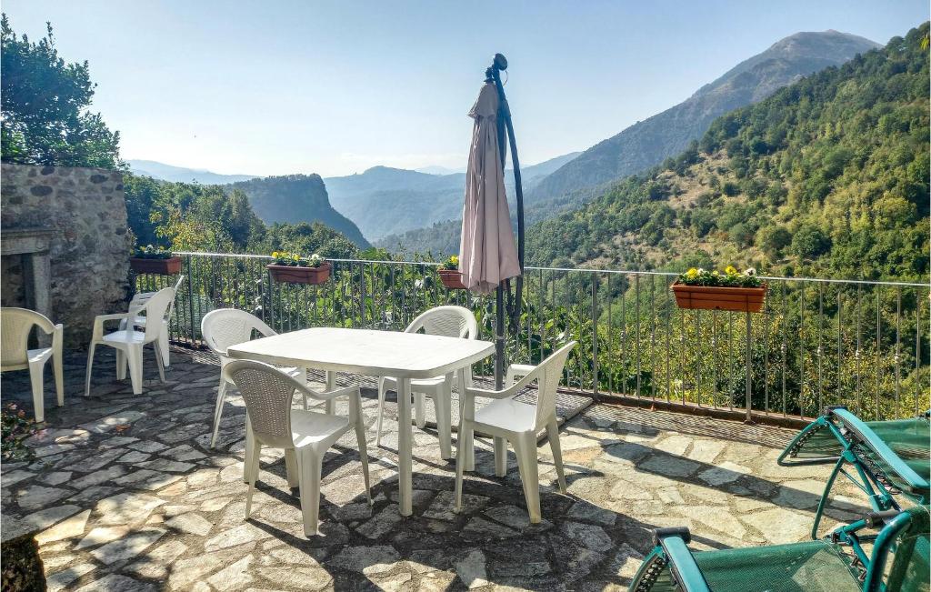 un patio con mesa, sillas y sombrilla en Nice Home In Limano With House A Mountain View, en Cocciglia