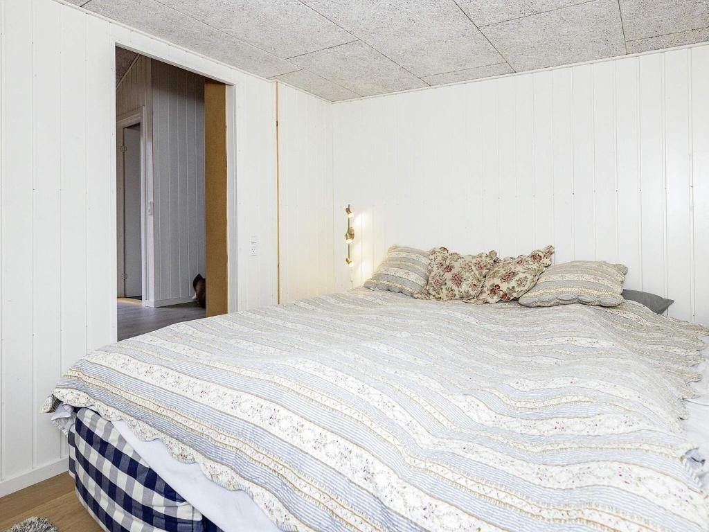 a bedroom with a large bed with pillows on it at Holiday home Rørvig XIII in Rørvig