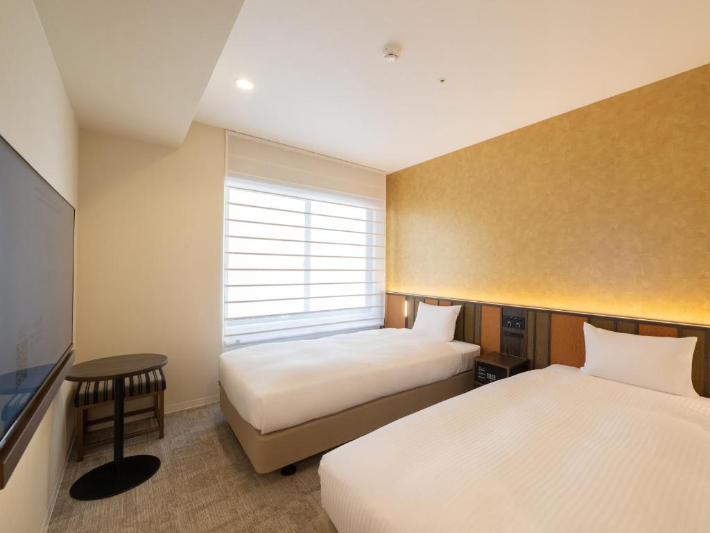Postel nebo postele na pokoji v ubytování Loisir Hotel Kyoto Toji