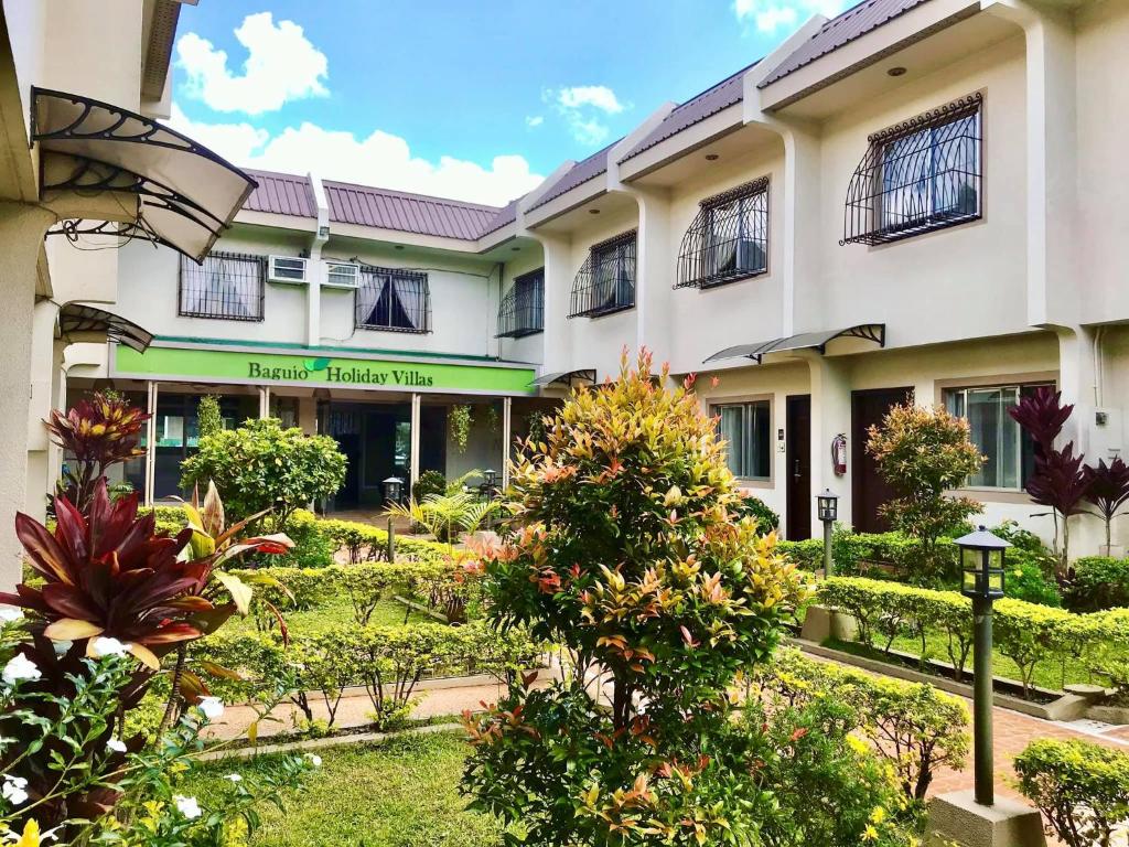 a building with a garden in front of it at Baguio Holiday Villas in Baguio