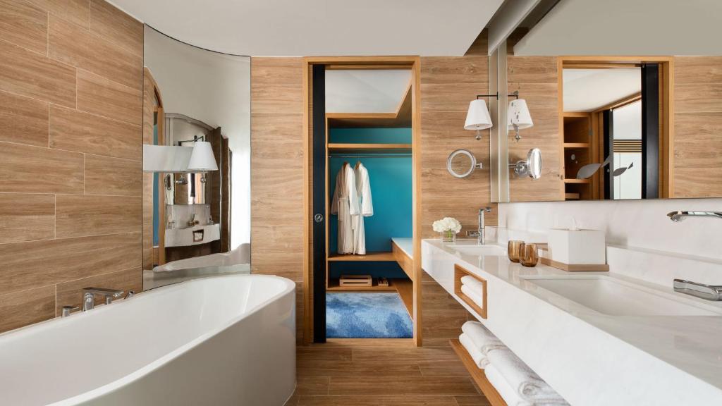 bagno con vasca, 2 lavandini e specchio di Hong Kong Ocean Park Marriott Hotel a Hong Kong