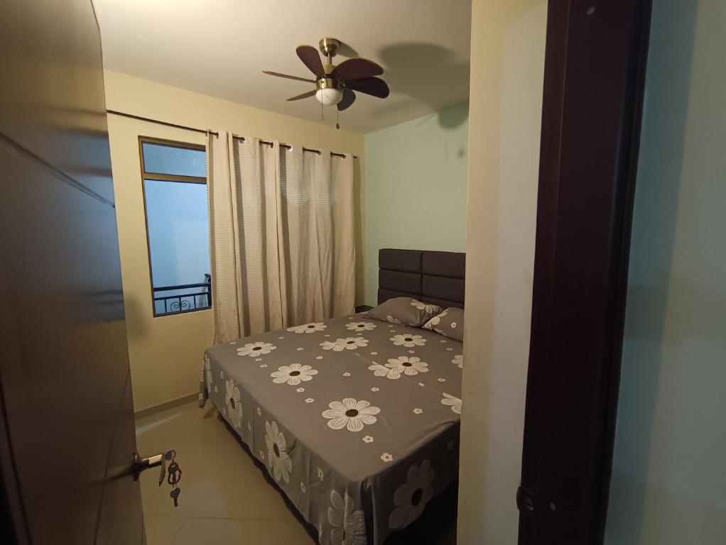 1 dormitorio con 1 cama y ventilador de techo en La terraza casa de verano, en Melgar