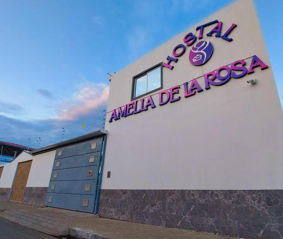 un bâtiment avec un panneau sur son côté dans l'établissement Hostal Amelia de la Rosa, à Manta