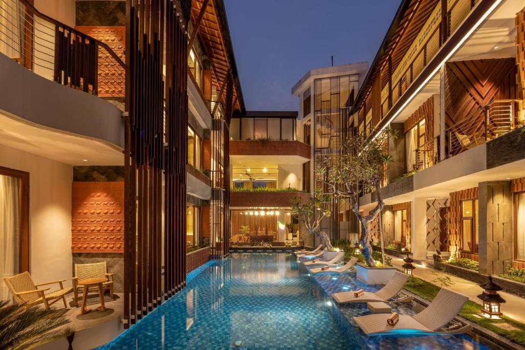 a swimming pool in the middle of a building at Mokko Suites Batubelig in Canggu