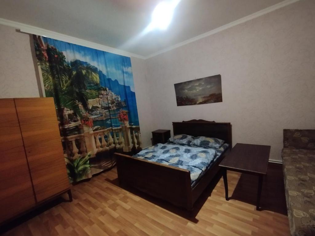 1 dormitorio con 1 cama y una pintura en la pared en GuestHouse ED&ER near airport, en Geghanist