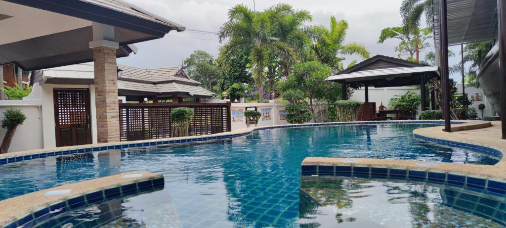een zwembad in een villa met een huis bij บ้านเรือสำราญ in Ban Nong Ket Yai