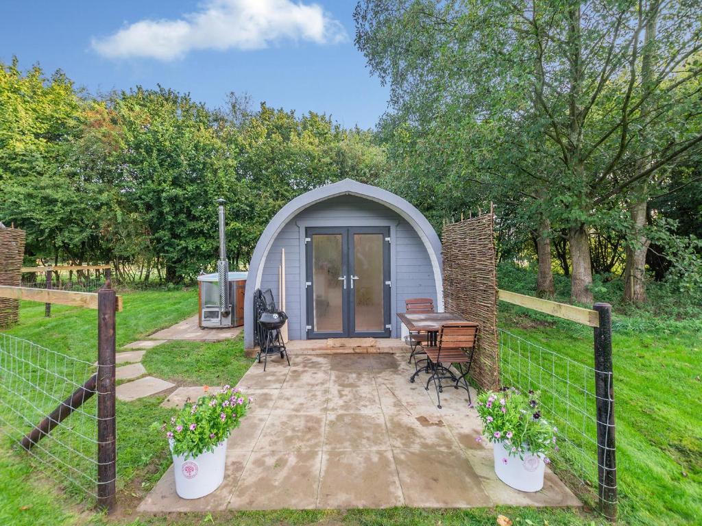 a small shed with a table and chairs in a yard at Barn Owl - Uk45517 in Humberstone