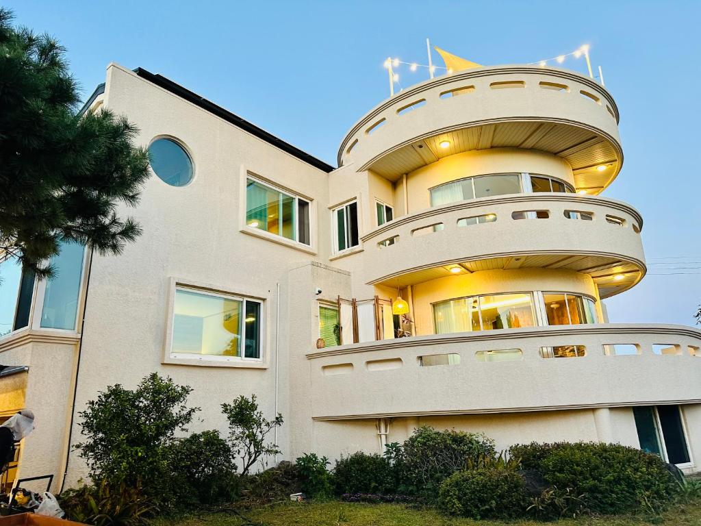 ein großes weißes Gebäude mit einem runden Fenster in der Unterkunft Seogwipo Classic in Seogwipo