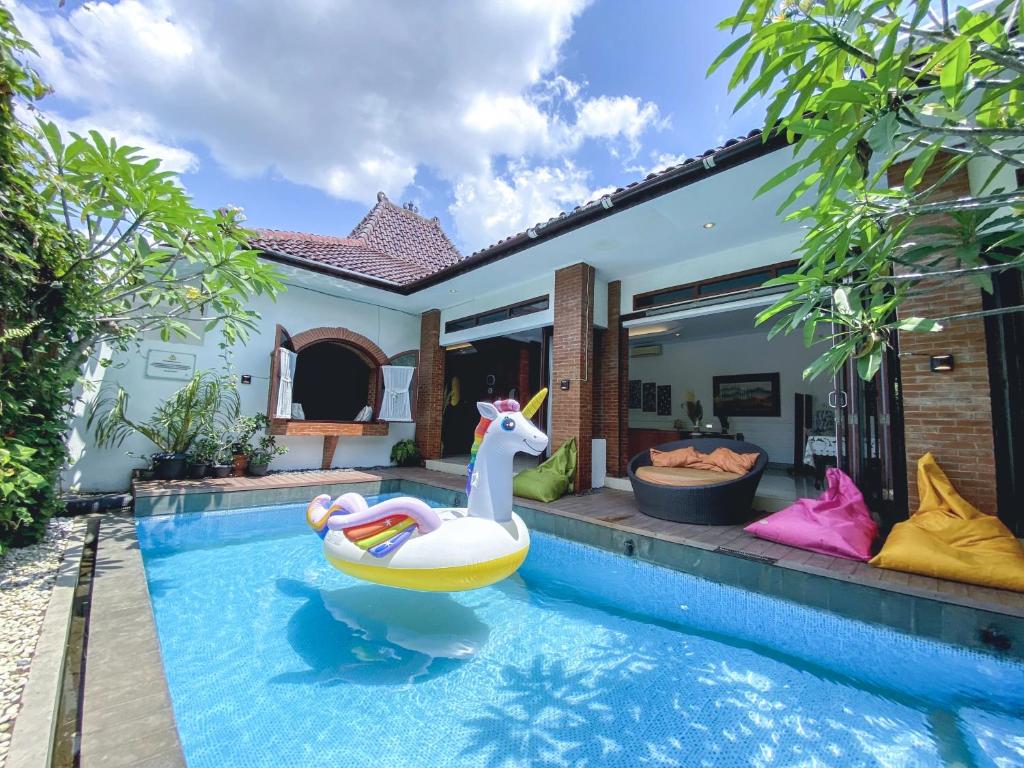 a pool with a unicorn float in a house at Ubu Villa Balirejo at Yogyakarta City Center in Demangan