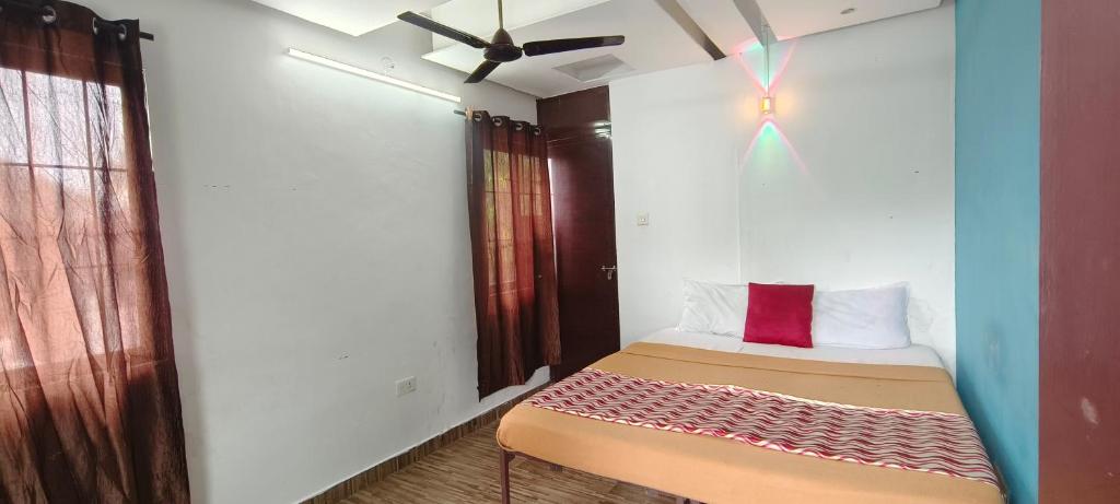 a small bedroom with a bed with a red pillow at kvm rooms and dormitory in Ernakulam
