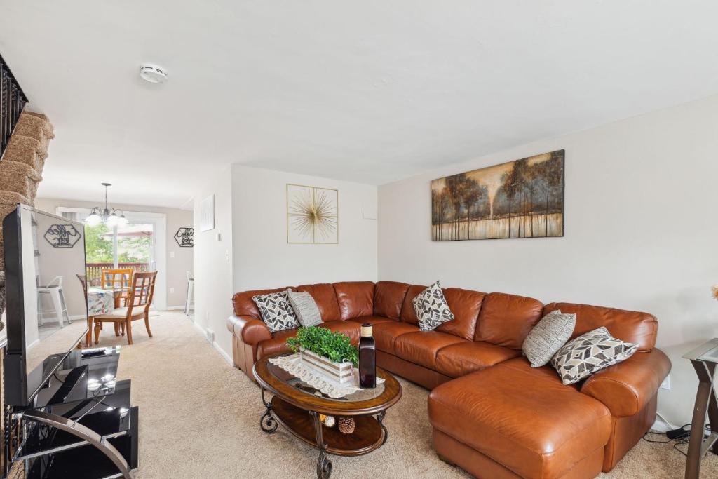 a living room with a brown leather couch at Charming Glenolden Townhouse in Glenolden