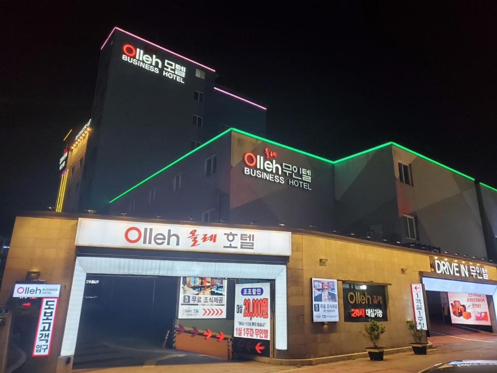 una tienda con letreros al lado de un edificio en Olle Business Hotel, en Gwangju