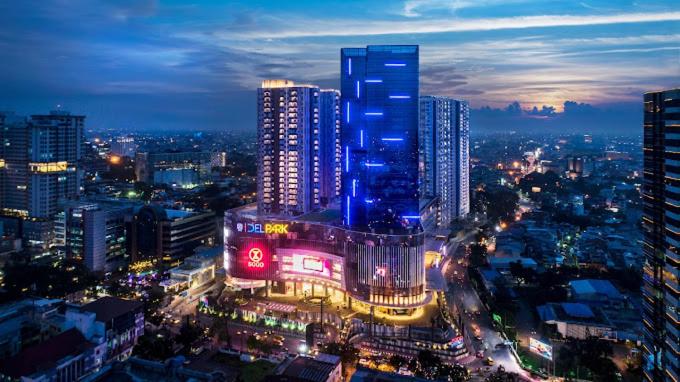una ciudad iluminada por la noche con edificios altos en APARTEMEN PODOMORO CITY DELI, en Medan
