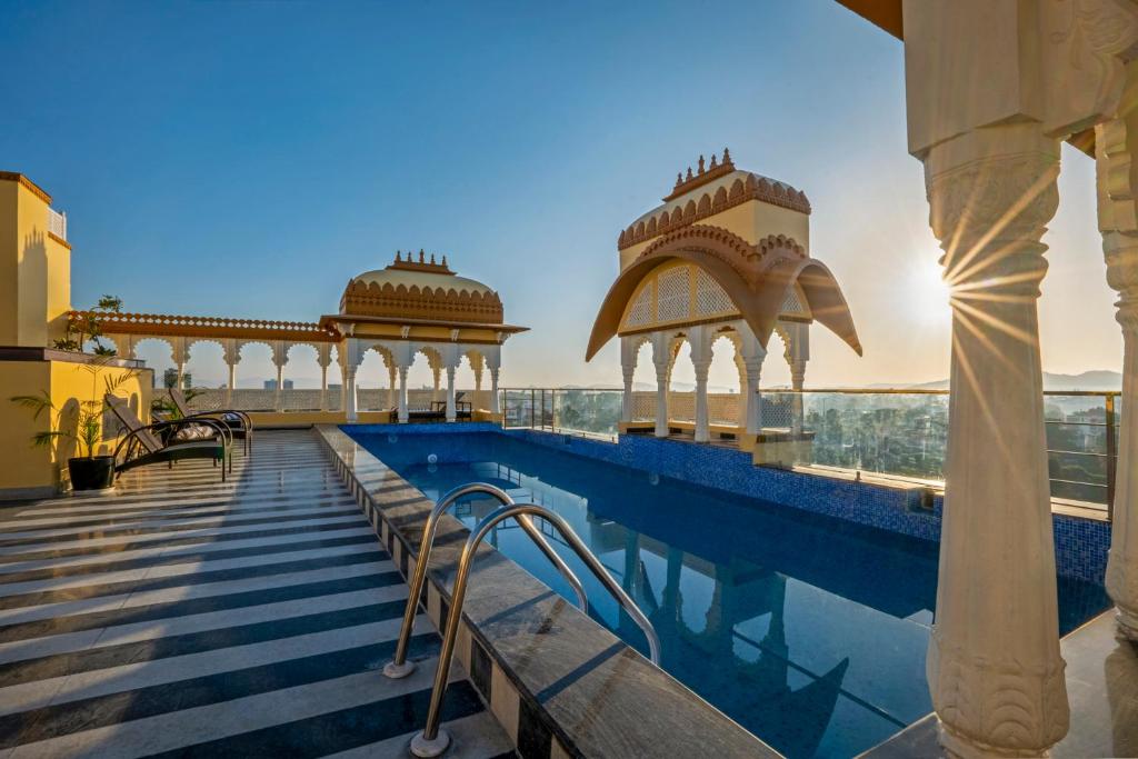 a swimming pool on the roof of a building at Sterling Balicha Udaipur in Udaipur