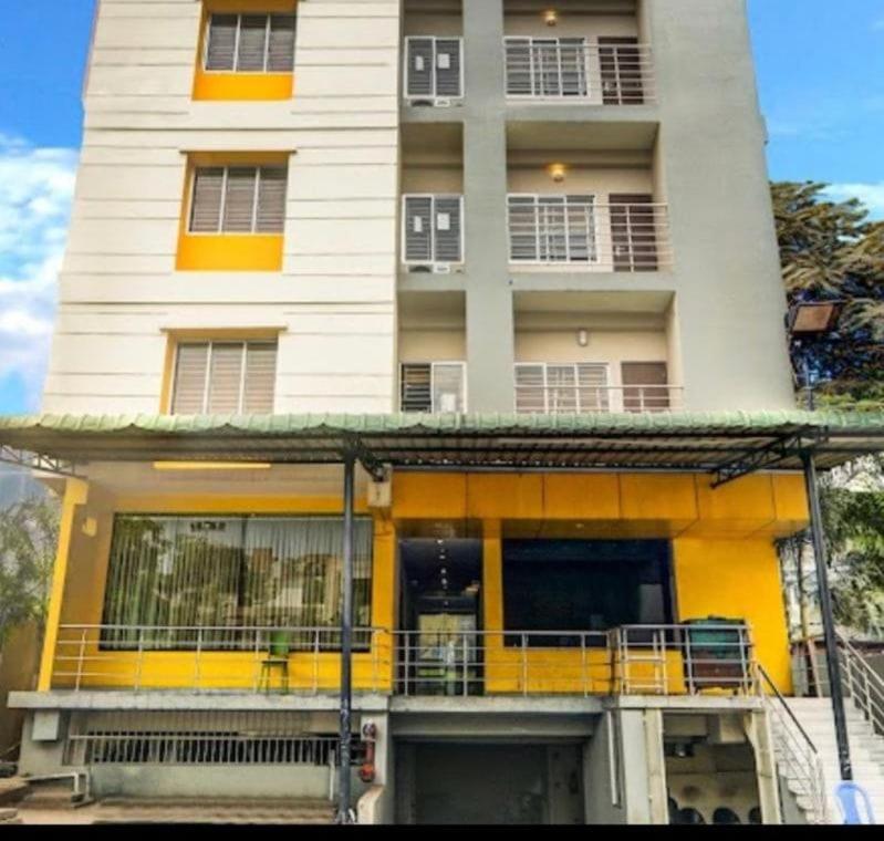 a large white building with a balcony in front of it at NirVana Lodge in Guwahati