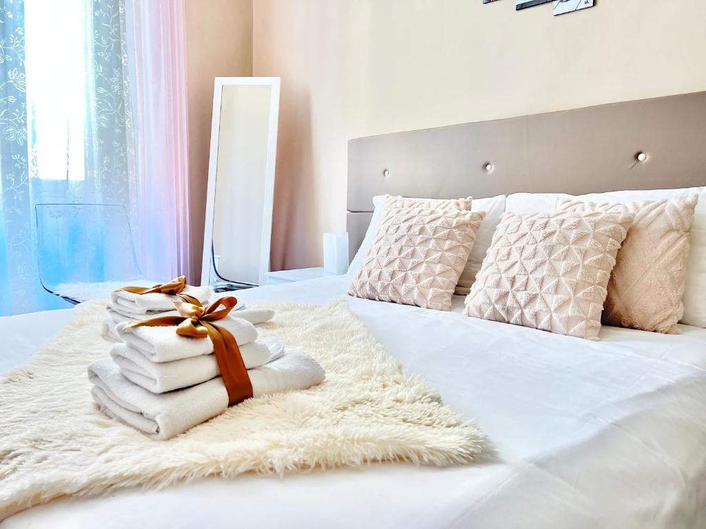 ローマにあるCasa Camillaの白いベッド(タオルを積み重ねて置いてある)