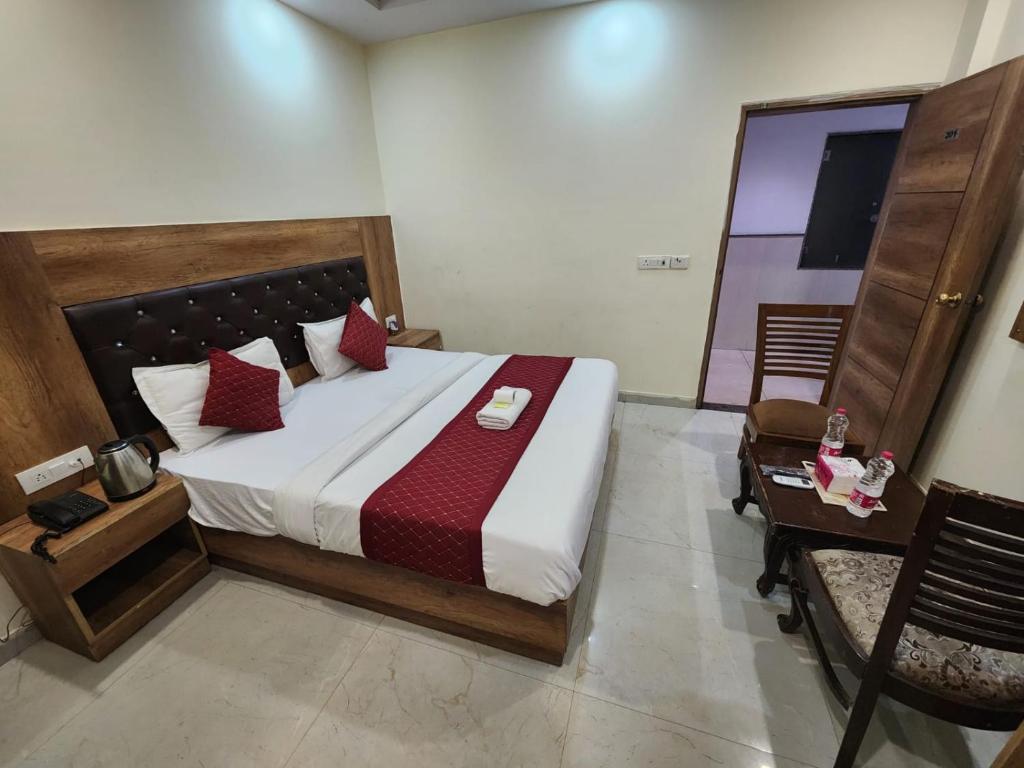 um quarto com uma cama grande e uma cadeira em Hotel AMBE INN By Ambience Delhi IGI Airport em Nova Deli