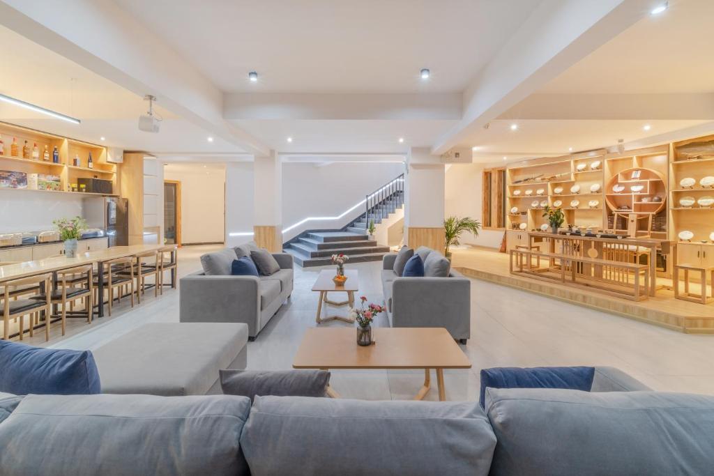 una sala de estar con sofás azules y una escalera. en Shangri-La Jinwushe Boutique Inn, en Shangri-La